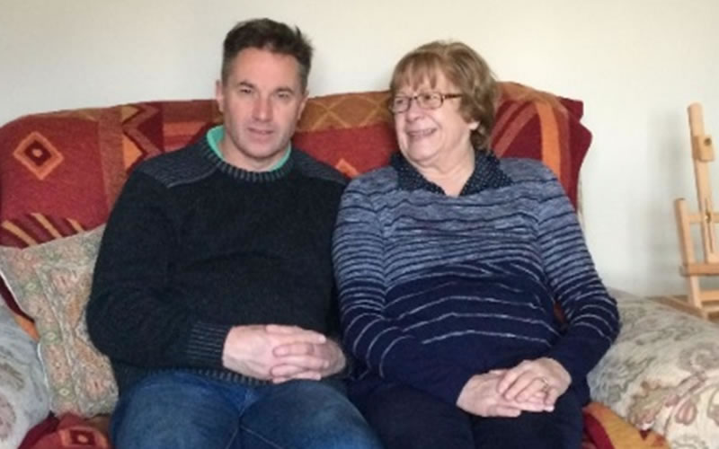 Older man sitting on sofa with his mother