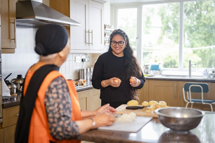 Older housemate with younger person helping to cook -Pictures Peter Kindersley