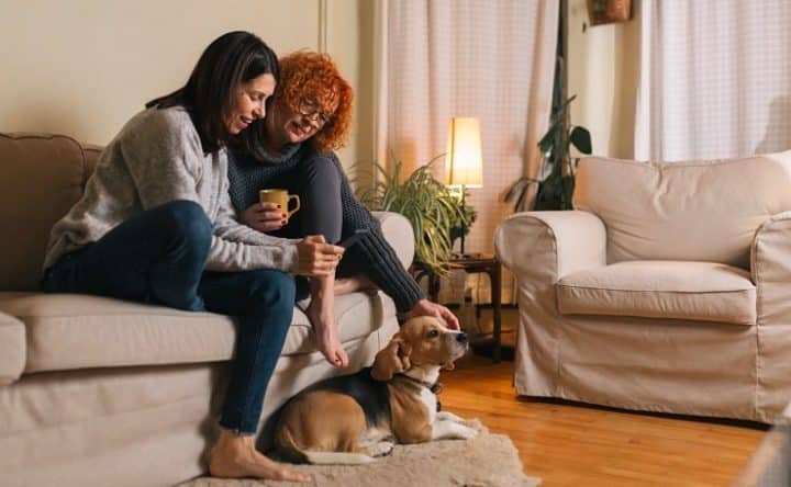Two women sharing a house sitting on a sofa