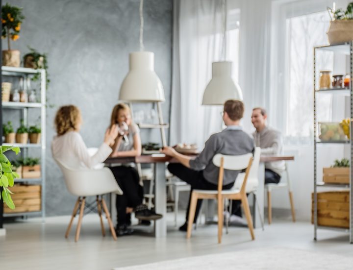 Group of four adults sitting around a table in an apartment