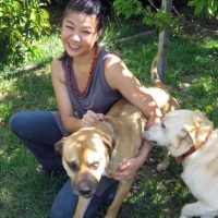 girl with two dogs in garden