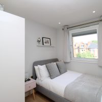 Clean bright room with double bed and window and wardrobe