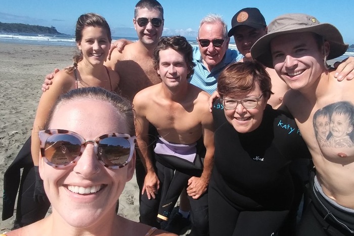 Grandparents, parent and grown children on the beach.