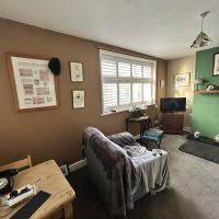 Room with chair and beige and green walls