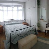 Bright room with window and iron bestead with light blue cover