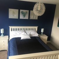 Dark blue room with white bedstead
