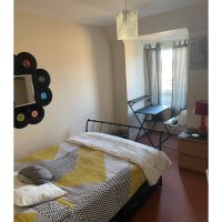 Brightly coloured bed spread in light single room