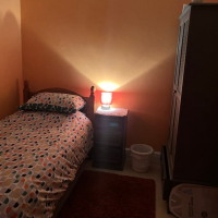 Cosy lit single rom with orange coloured walls