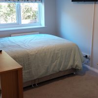 Window with wall mounted TV and double bed