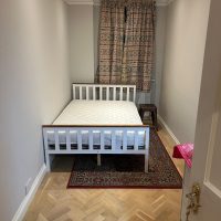 Room with single bed and curtains closed